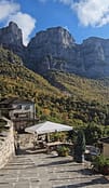 Outdoor terrace with umbrella and tables facing the Astraka mountain in Mikro Papigo.
