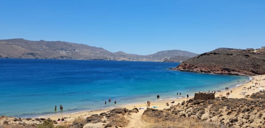 Agios Sostis Beach in Mykonos with a turquoise bay, sandy shore, and natural landscape